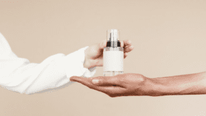 Close-up de pessoa segurando um frasco de perfume