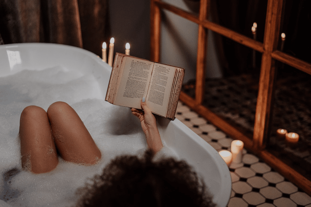 Mulher lendo livro enquanto aproveita o frescor do banho