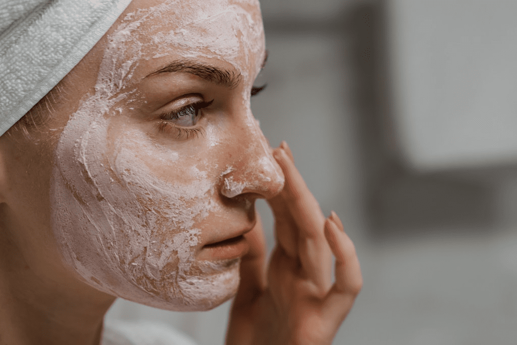 Close-up de uma mulher aplicando creme facial de proteção solar